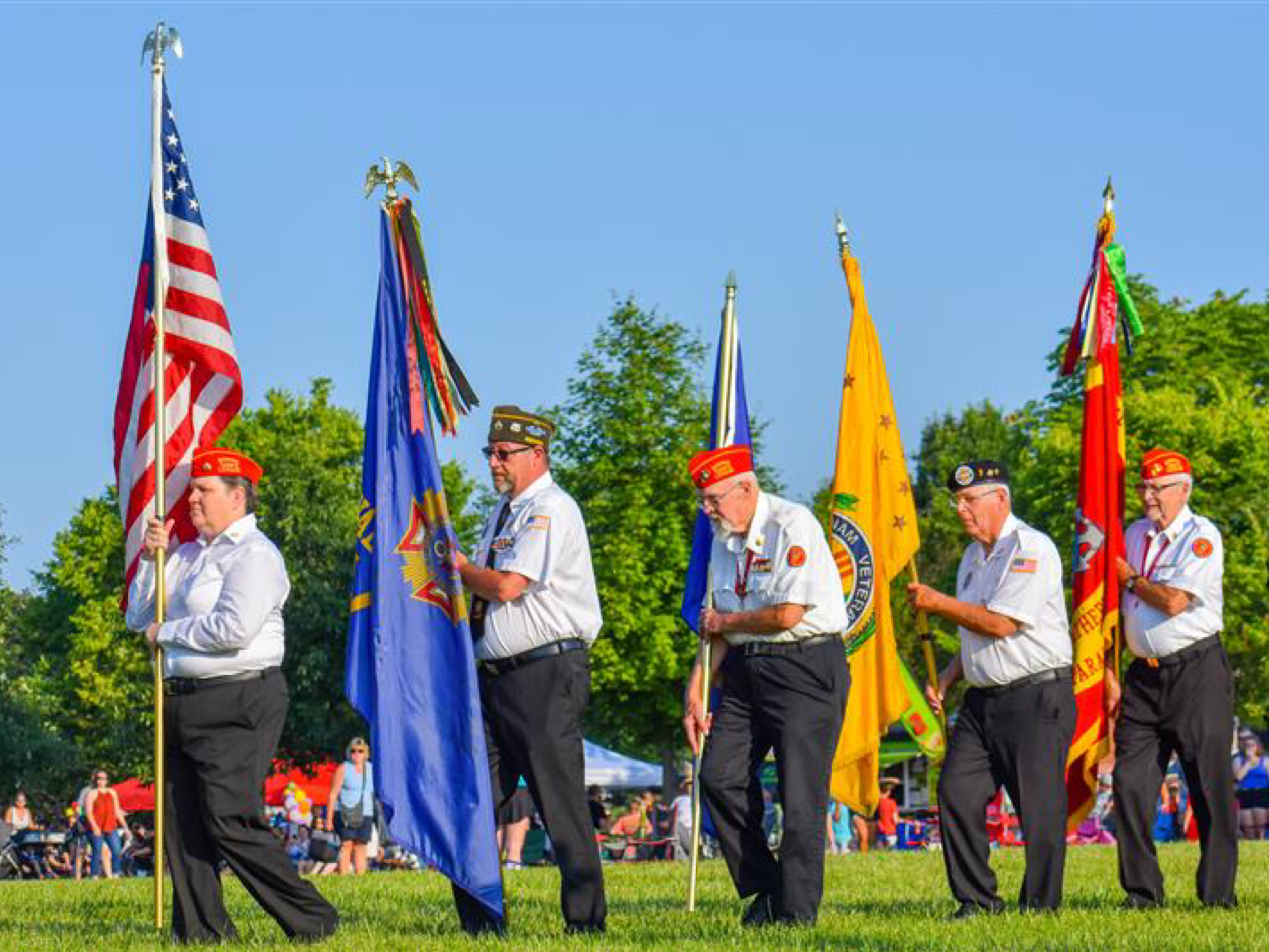 5 people in uniform carrying various flags for organizations in the Unites States 5 people in uniform carrying various flags for organizations in the Unites States
