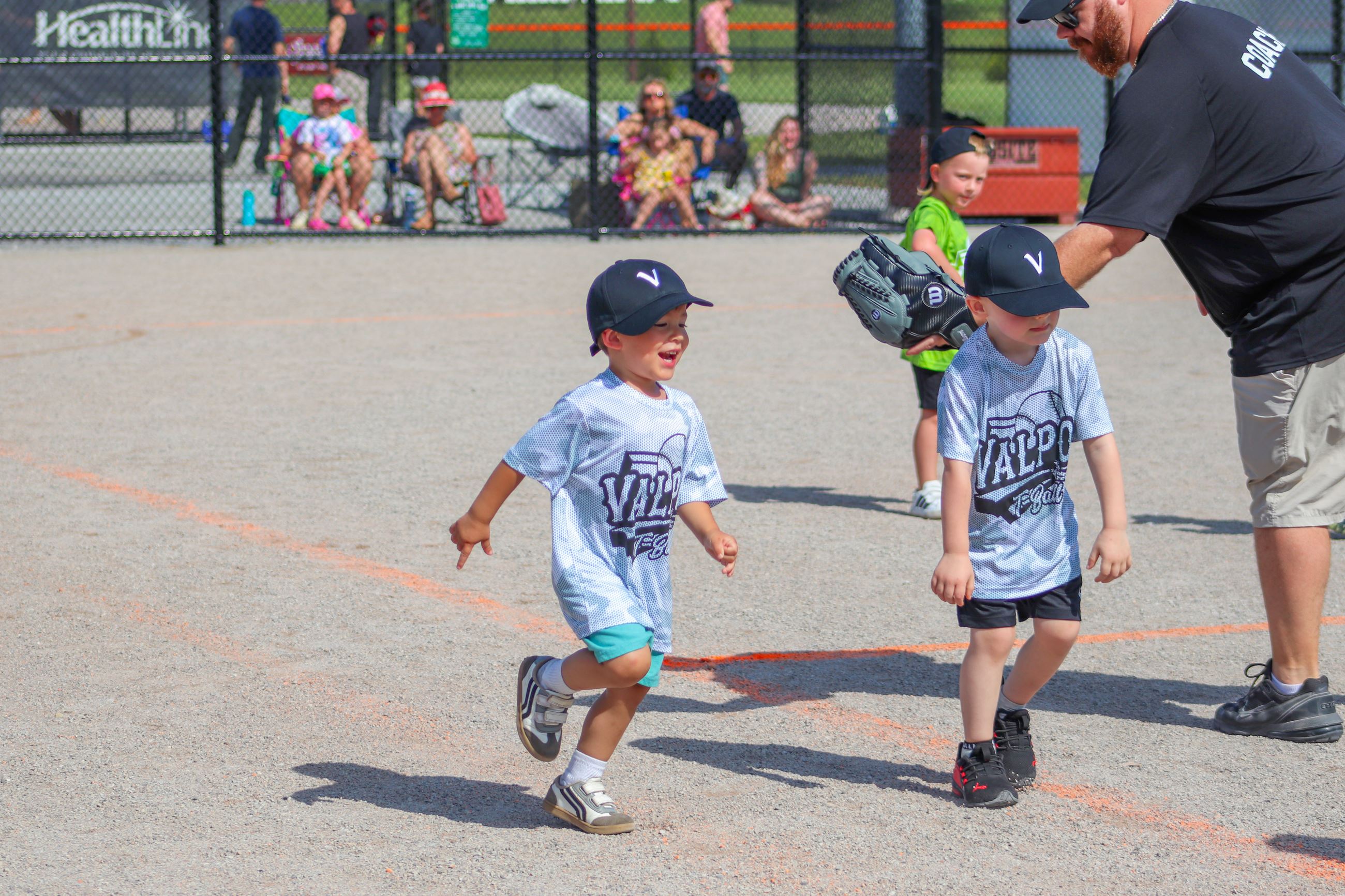 Kids in T-Ball jerseys on a baseball field
