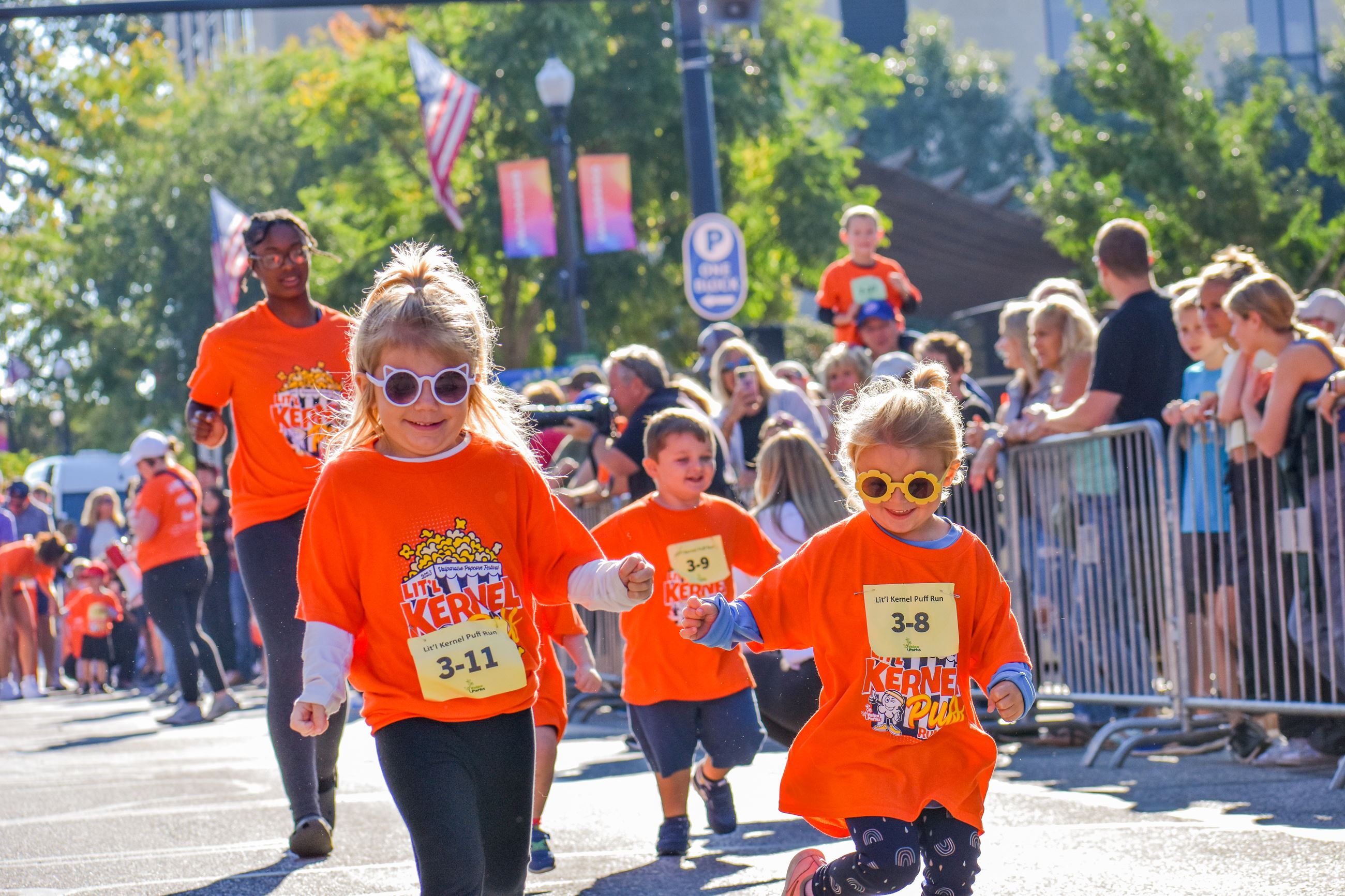 3 children running a race, wearing matching shirts